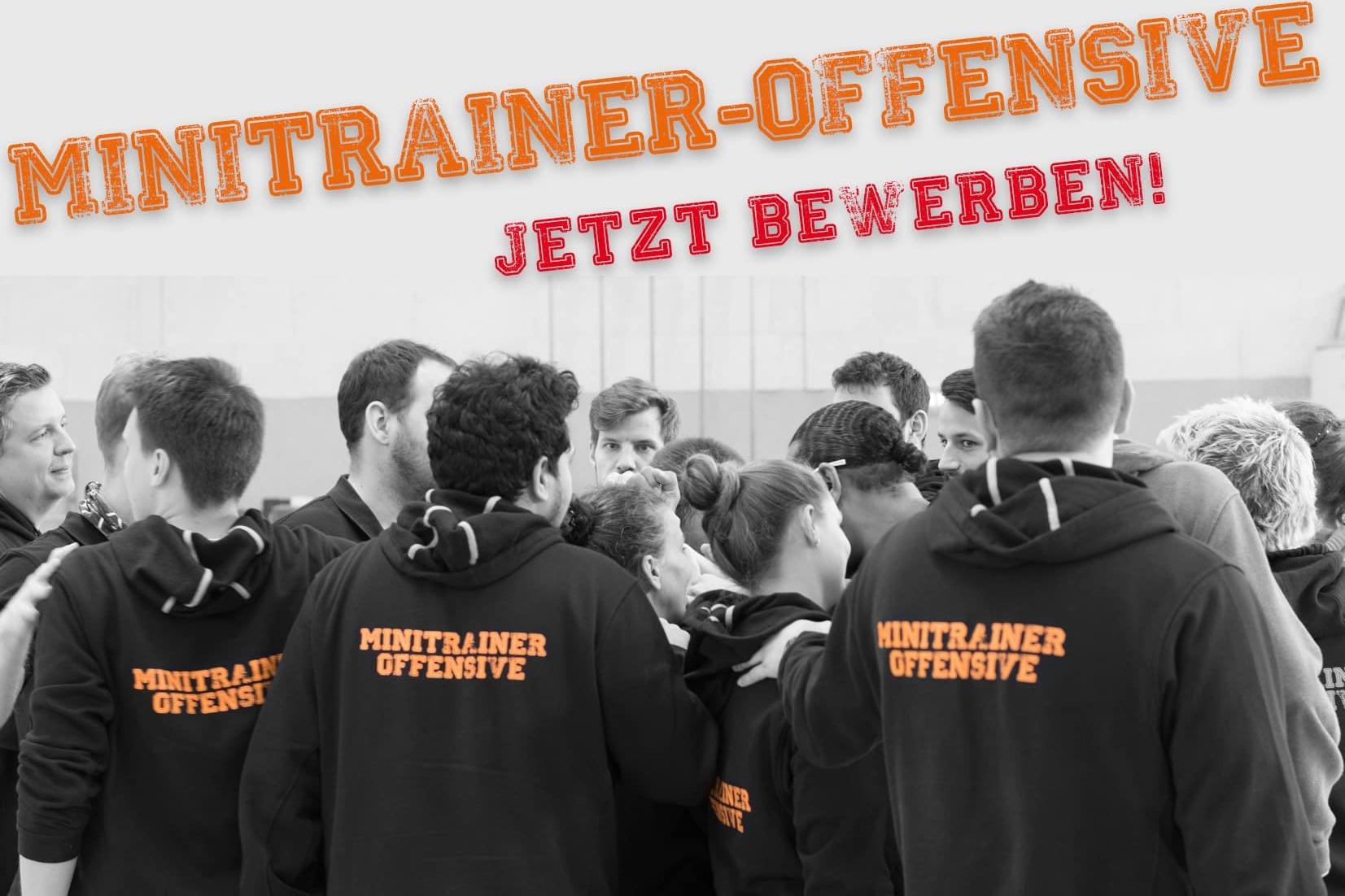 Gruppierung junger Trainer in schwarzen Hoodies mit dem Schriftzug &bdquo;Minitrainer-Offensive&ldquo; in einem Sportumfeld.