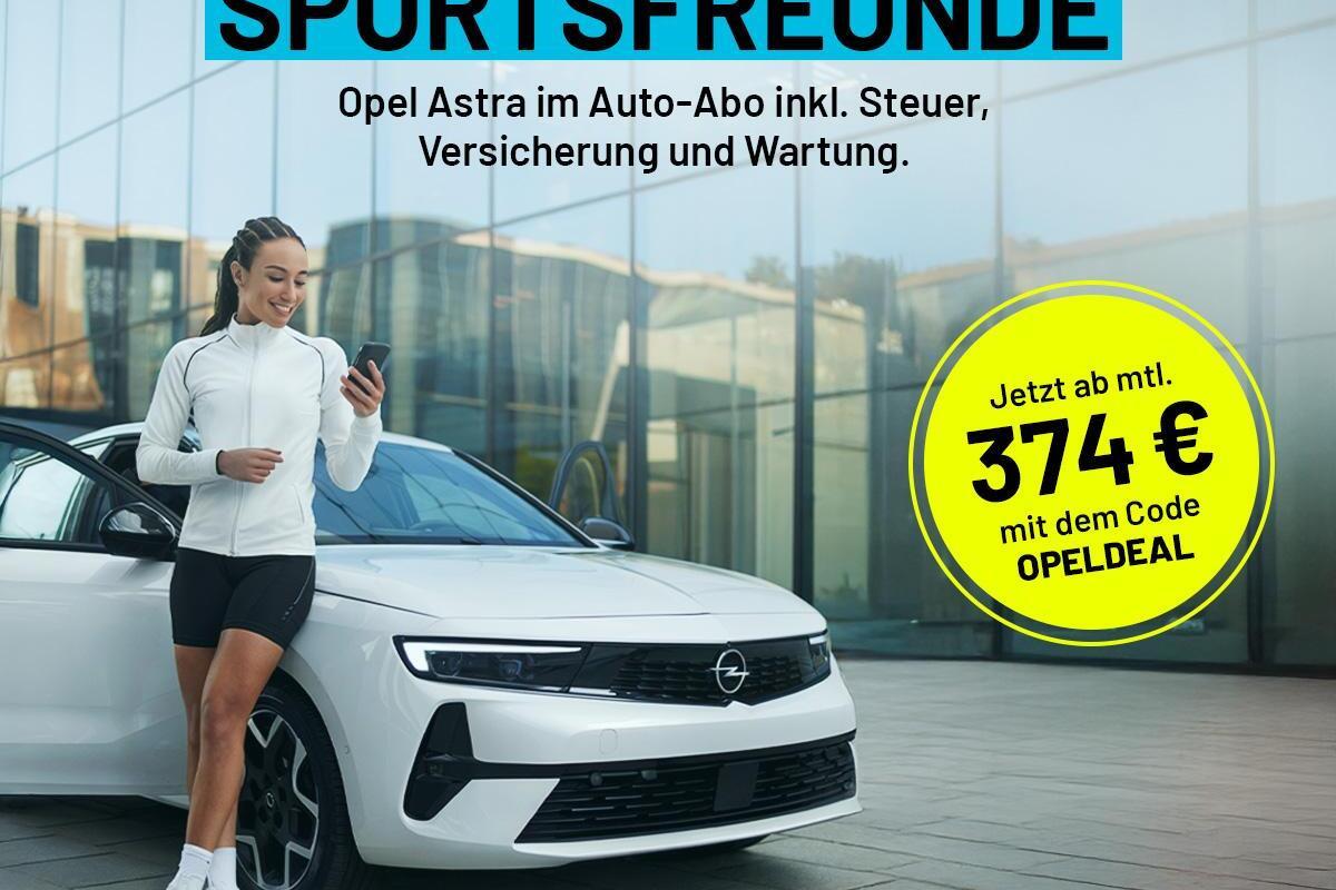 Frau in Sportkleidung steht neben einem wei&szlig;en Opel Astra und betrachtet ihr Smartphone, moderne Architektur im Hintergrund.
