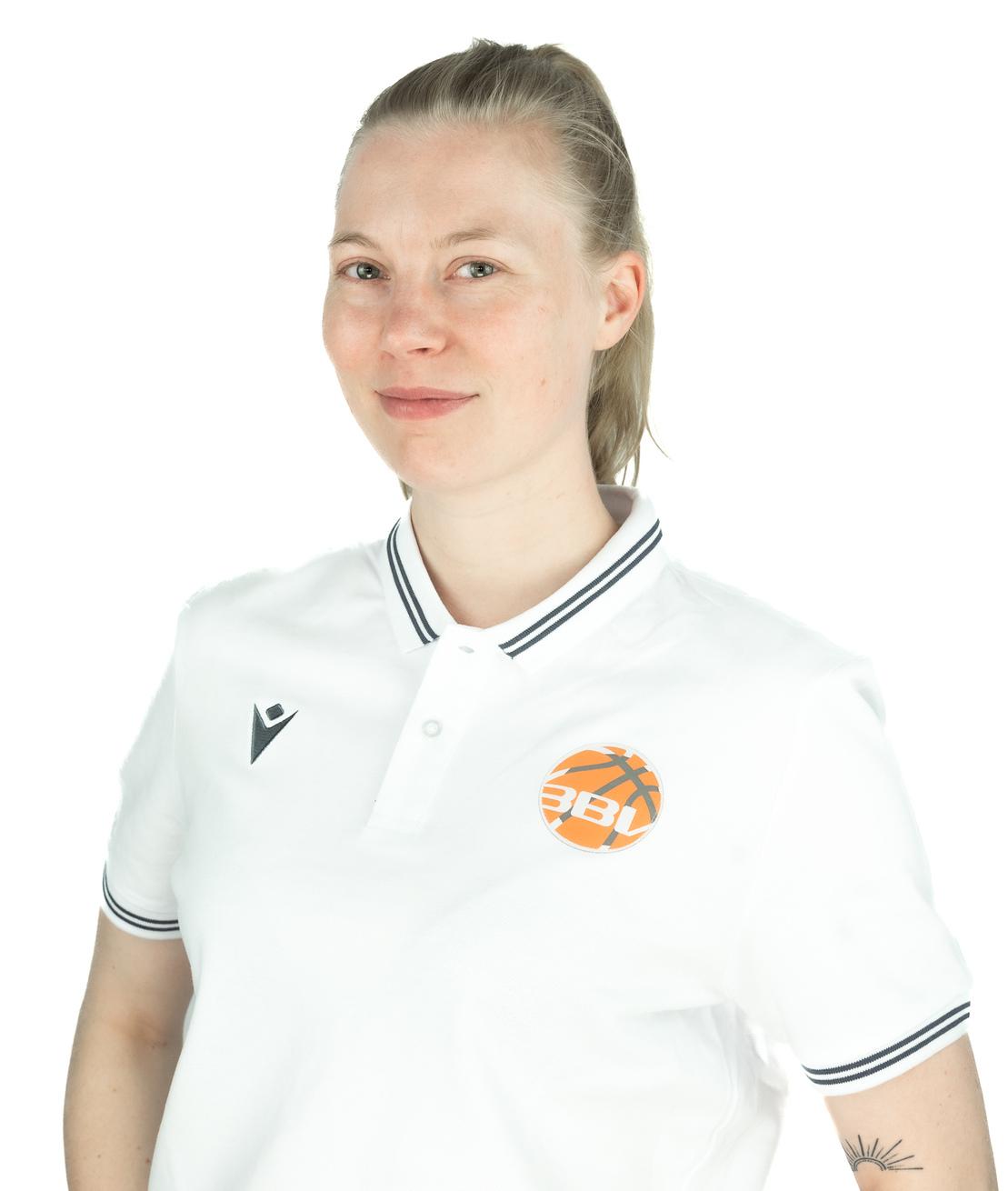 Portr&auml;t einer Frau mit blonden Haaren im wei&szlig;en Poloshirt mit Basketball-Logo auf einem wei&szlig;en Hintergrund.
