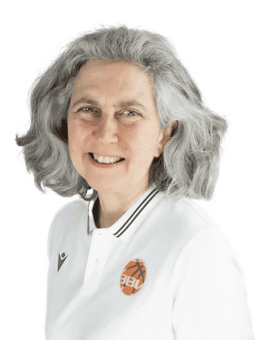 L&auml;chelnde Frau mit grauen Locken tr&auml;gt ein wei&szlig;es Polo-Shirt mit Basketball-Logo.